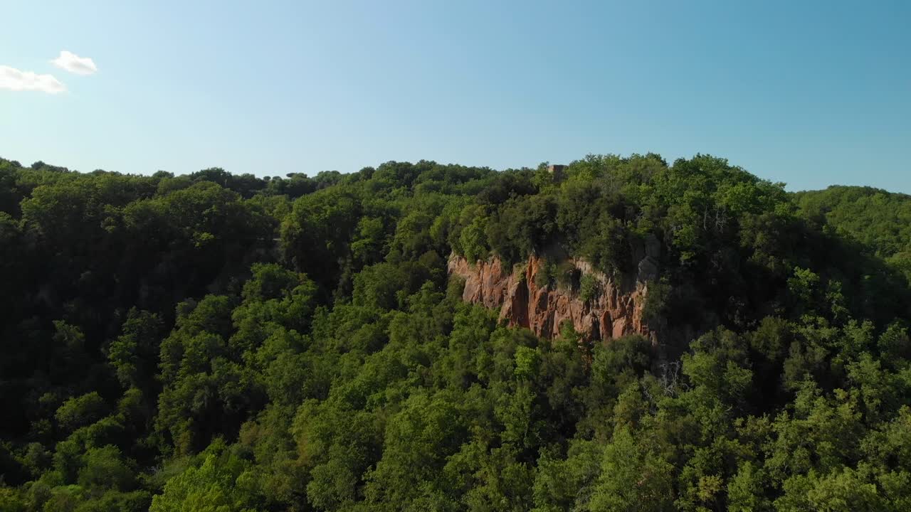 plataforma rodante aérea en: dron que se eleva sobre un valle verde, con bosques de verano, algunas montañas rocosas y un cielo azul, italia, antena 4k