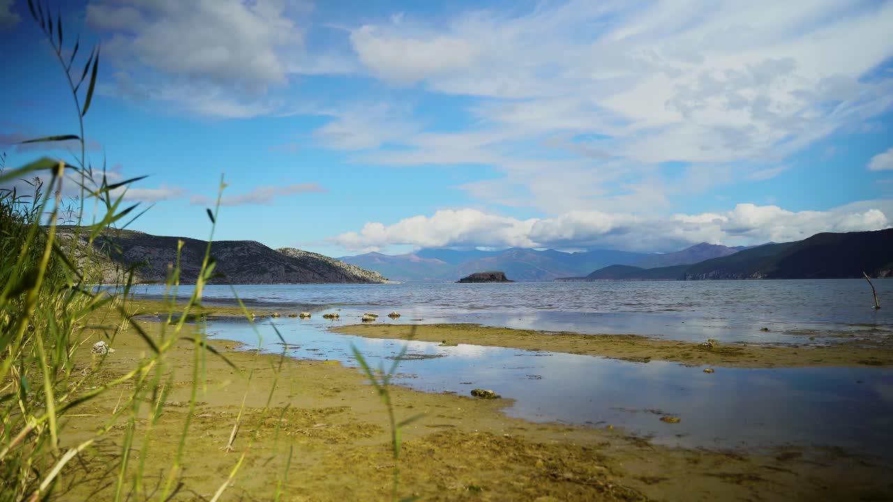 lago de montaña de prespa con una pequeña isla rodeada de agua en un hermoso fondo de cielo nublado