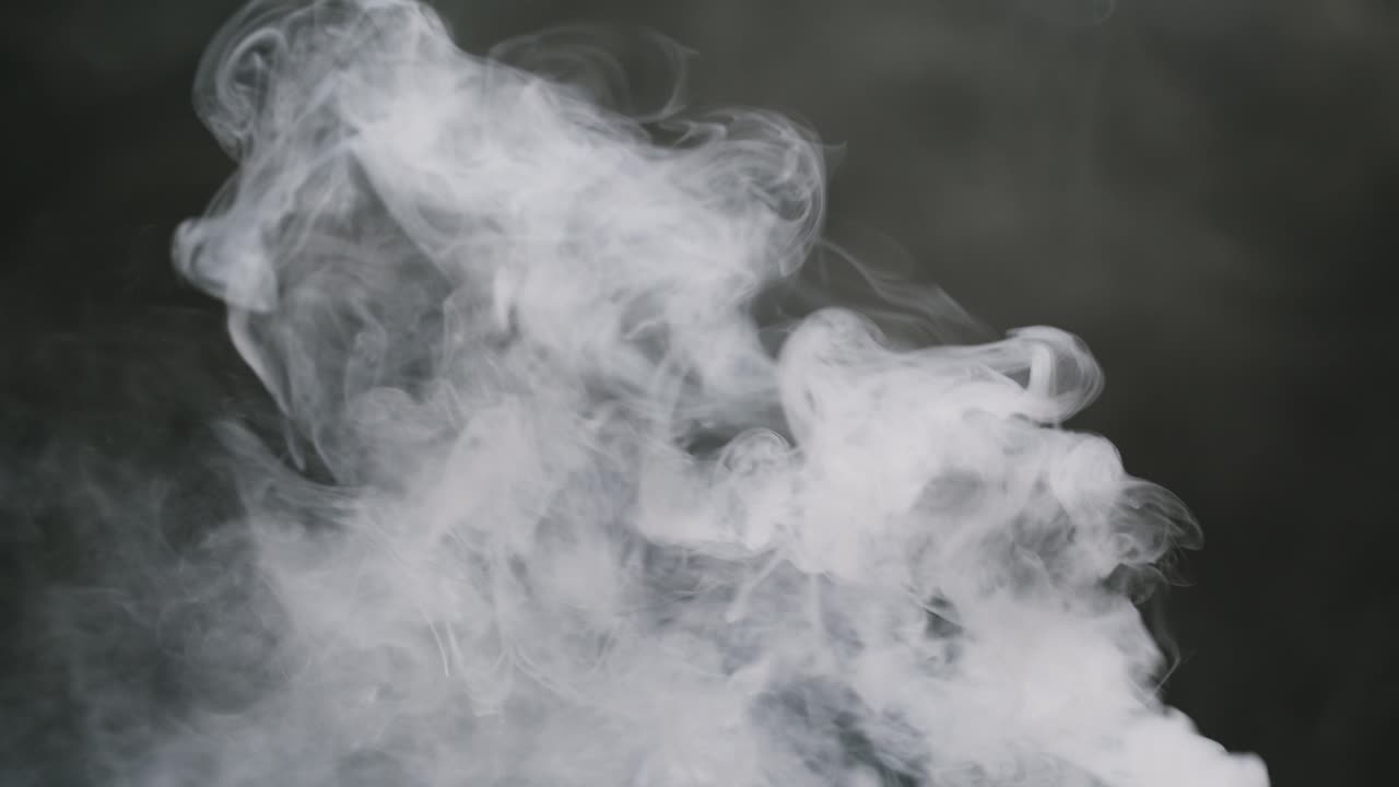 White Smoke Rising and Spreading Against a Dark Background