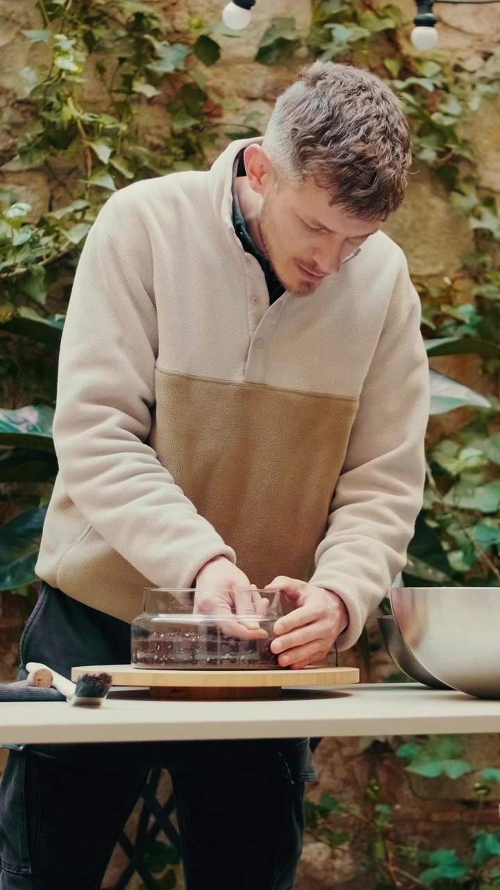 Hombre preparando cuidadosamente un postre de chocolate en un entorno al aire libre