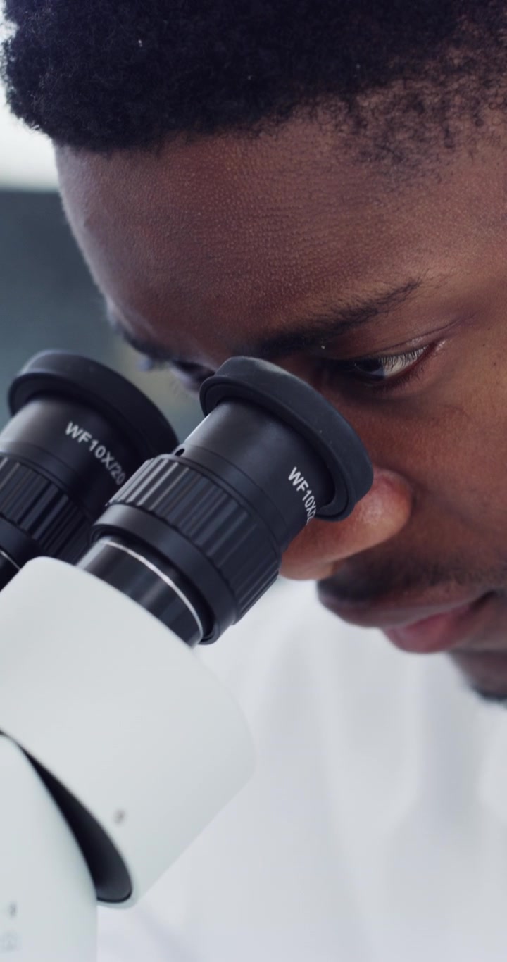 Scienziato che esamina un campione di pianta al microscopio in laboratorio
