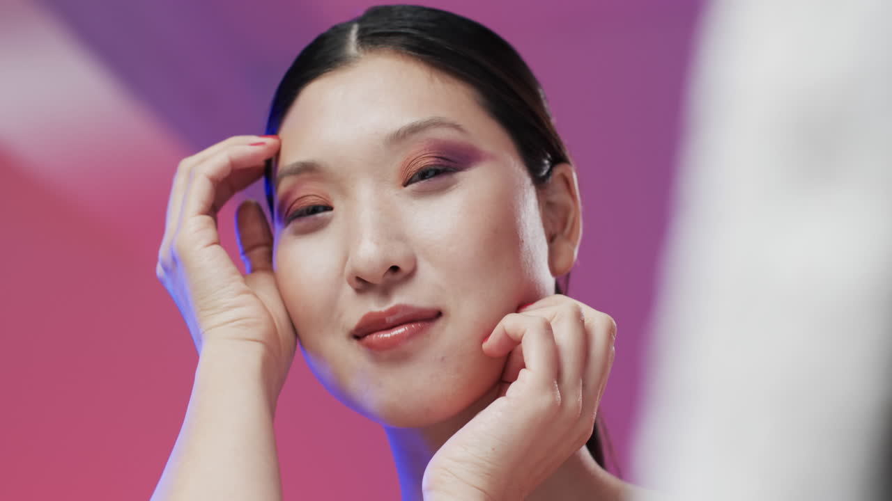 검은 머리카락과 메이크업을 가진 아시아 여성 만지는 얼굴, 복사 공간, 느린 동작