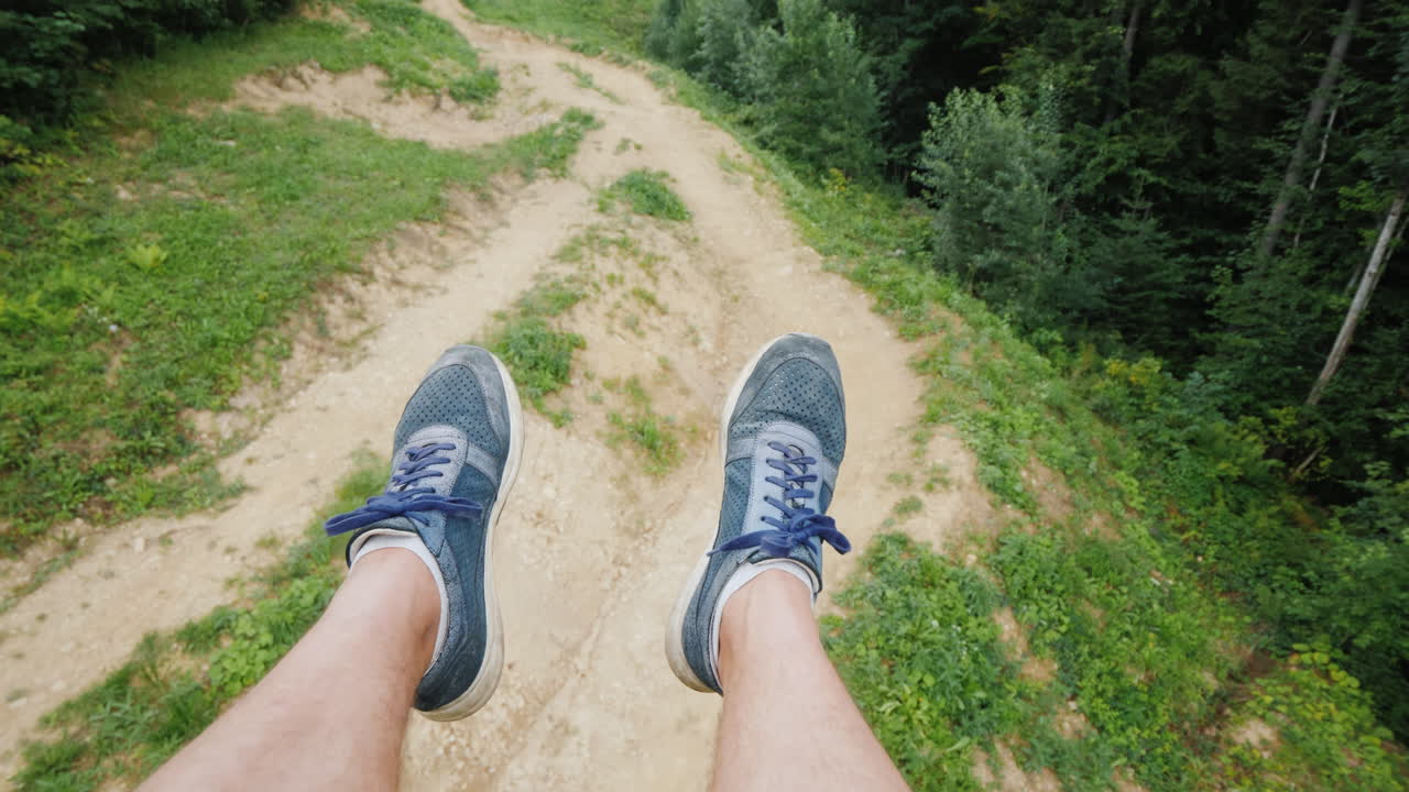 las piernas de los hombres vuelan sobre las montañas una persona va al remonte en verano