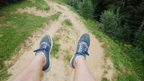 men's legs fly over the mountains a person goes to the ski lift in the summer