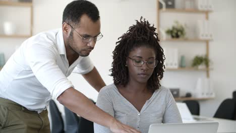 front view of two concentrated people working with laptop