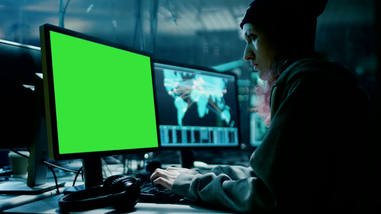 una adolescente hacker no conformista con cabello rosa ataca los servidores corporativos usando su computadora de pantalla verde. la habitación es oscura, de neón y tiene muchas pantallas.
