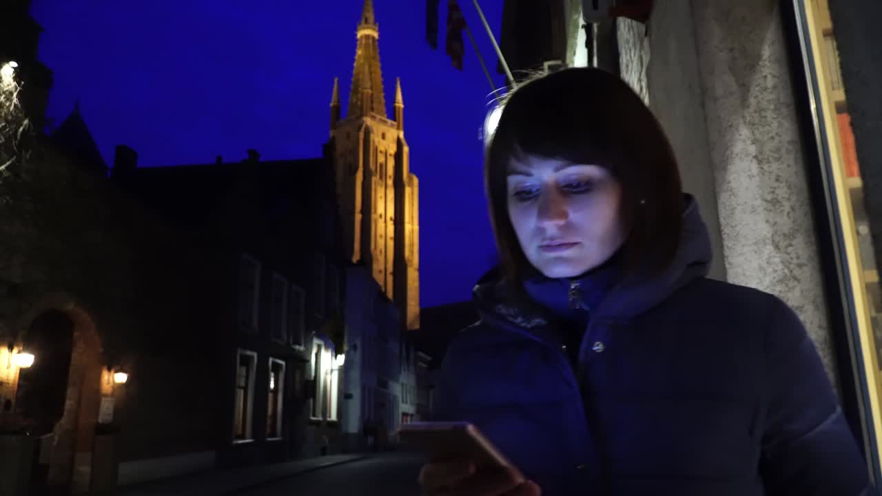 una chica turista camina por la noche en bruges, bélgica.