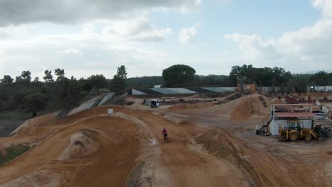 épica vista trasera en cámara lenta del piloto de motocross saltando sobre la pista de tierra