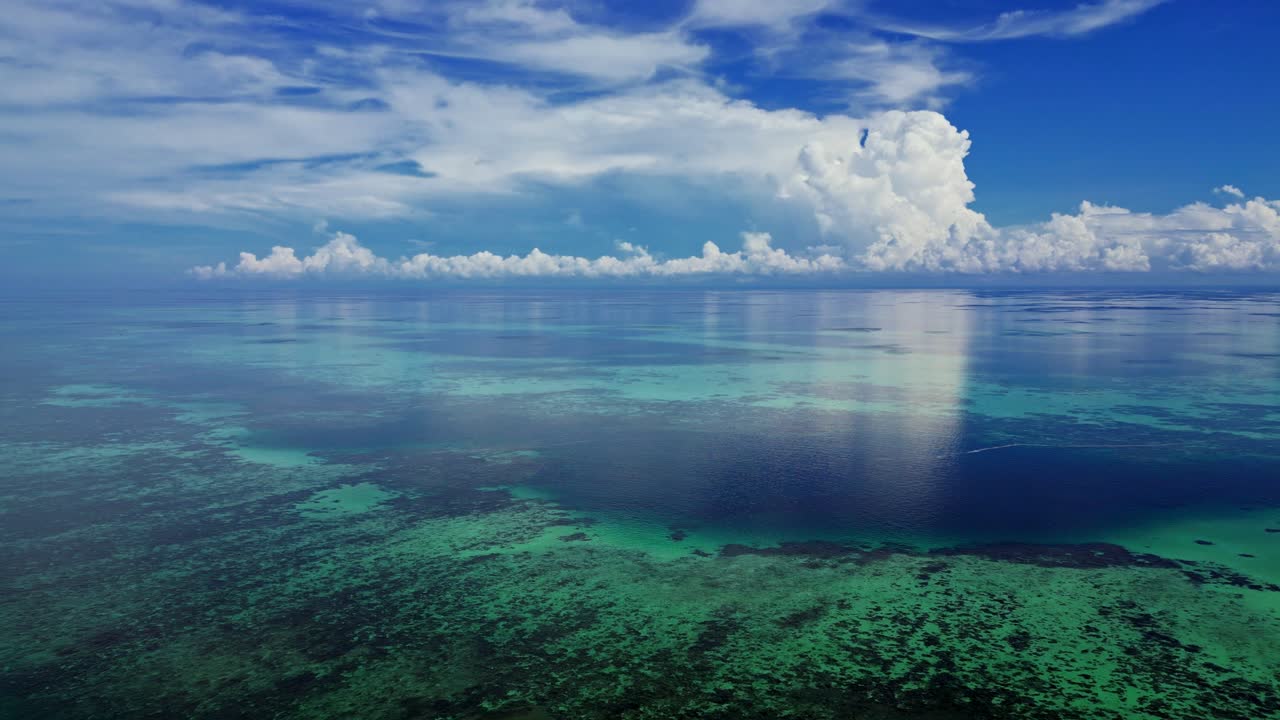 Drone flying over a huge coral reef system showing deep blue pools among the shallow reefs