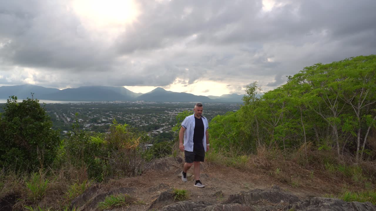 Man walking towards camera at lookout.
