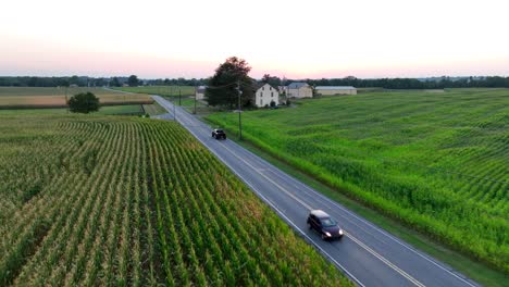 Black-truck-driving-on-country-road-in-USA-during-summer-sunset