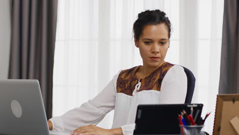 mujer de negocios sonriente escribiendo en una computadora portátil