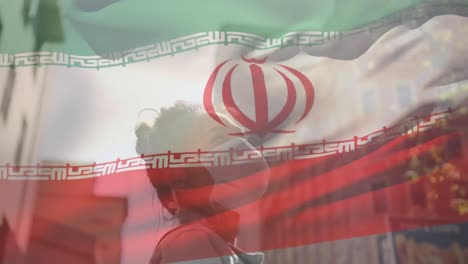 animación de la bandera de irán ondeando sobre una mujer afroamericana con máscara facial en la calle de la ciudad
