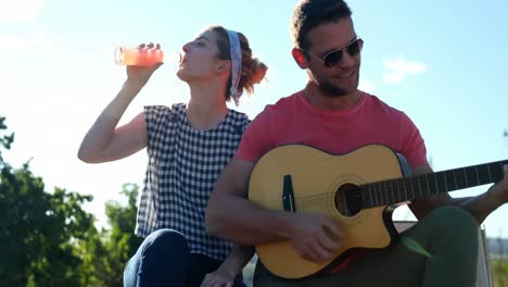hombre tocando la guitarra para mujer 4k