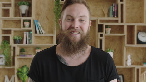 close up portrait of young cheerful hipster man with beard laughing happy feeling confident