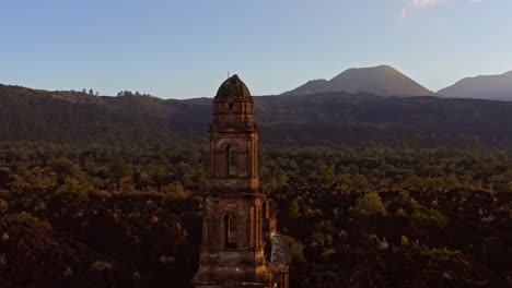 cinematic drone flight circles the lone tower of the ruined church of san juan parangaricutiro