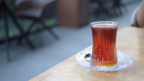 a glass of turkish tea on a table at a cafe