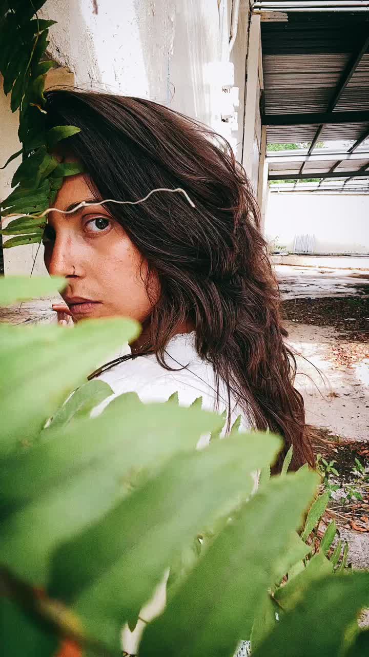 Woman Hiding Behind Fern in an Abandoned Building
