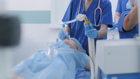 el anestesista y el equipo médico preparan a la paciente para la cirugía, ponen a la paciente en anestesia, regulan la máscara de oxígeno, el tubo endotraqueal. cirugía. anestesia