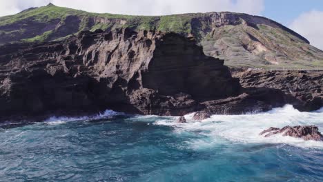 Imágenes-Aéreas-De-La-Costa-De-Oahu-Hawaii-Con-Aguas-Turquesas-Del-Océano-Pacífico-Y-Olas-Blancas-Rompiendo-La-Costa-De-Las-Formaciones-Volcánicas-Y-Exuberantes-Montañas-Al-Fondo