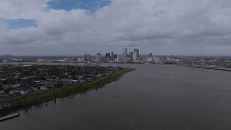 wide aerial flyout of downtown new orleans with clouds moving and the mississippi river below