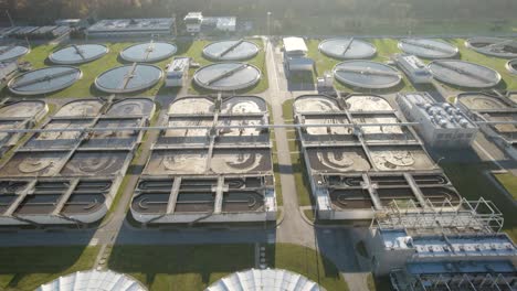 aerial trucking shot towards the sun over the huge wastewater treatment plant