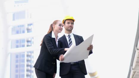 ingeniero y mujer de negocios sosteniendo el plan con hablar discutir el proyecto juntos. concepto de gestión de proyectos, reunión de negocios, estrategia e ingeniería.