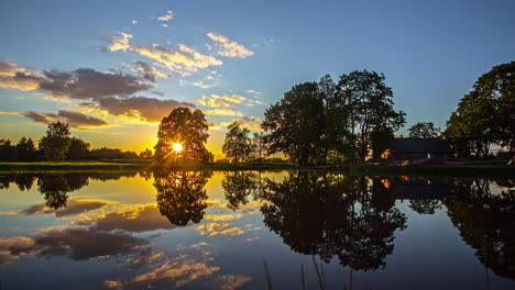 sun setting down with majestic cloudscape reflecting on calm lake surface, fusion time lapse