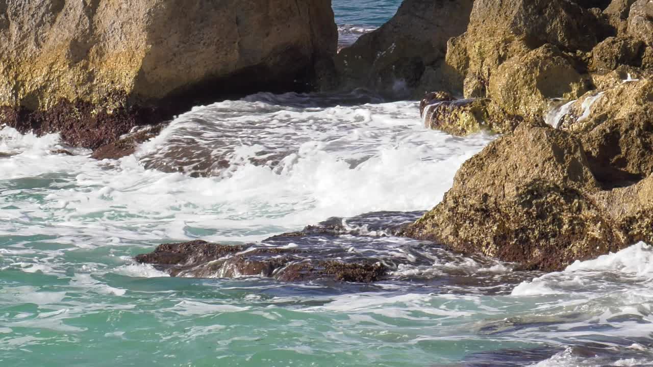 olas oceánicas rompiendo sobre rocas en spray blanco, mar mediterráneo españa