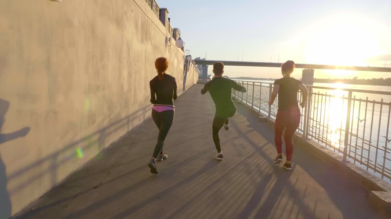 Group Exercise by the River at Sunrise