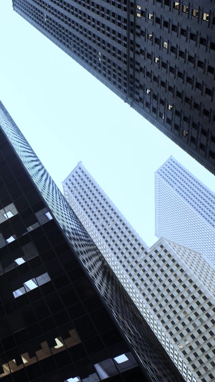 Rascacielos reflejan el cielo en una ciudad concurrida al mediodía.