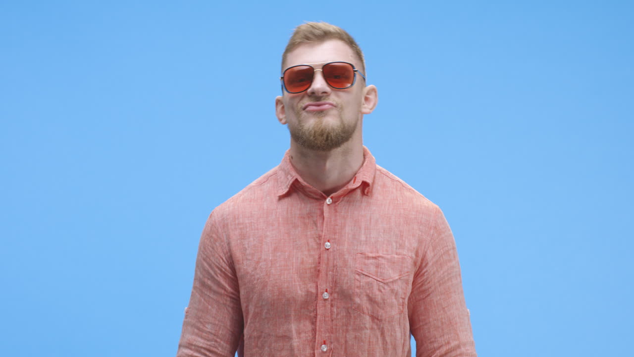 Man Adjusting Sunglasses and Smiling