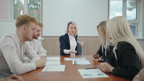 nervous and angry female boss is communicating with employees during business meeting