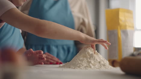 cocina de la casa la familia está cocinando juntos harina en la mesa y las manos de la niña en primer plano