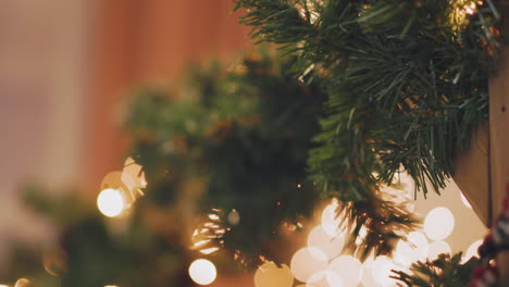 mujer de mano decorando el árbol de navidad con luces navideñas.