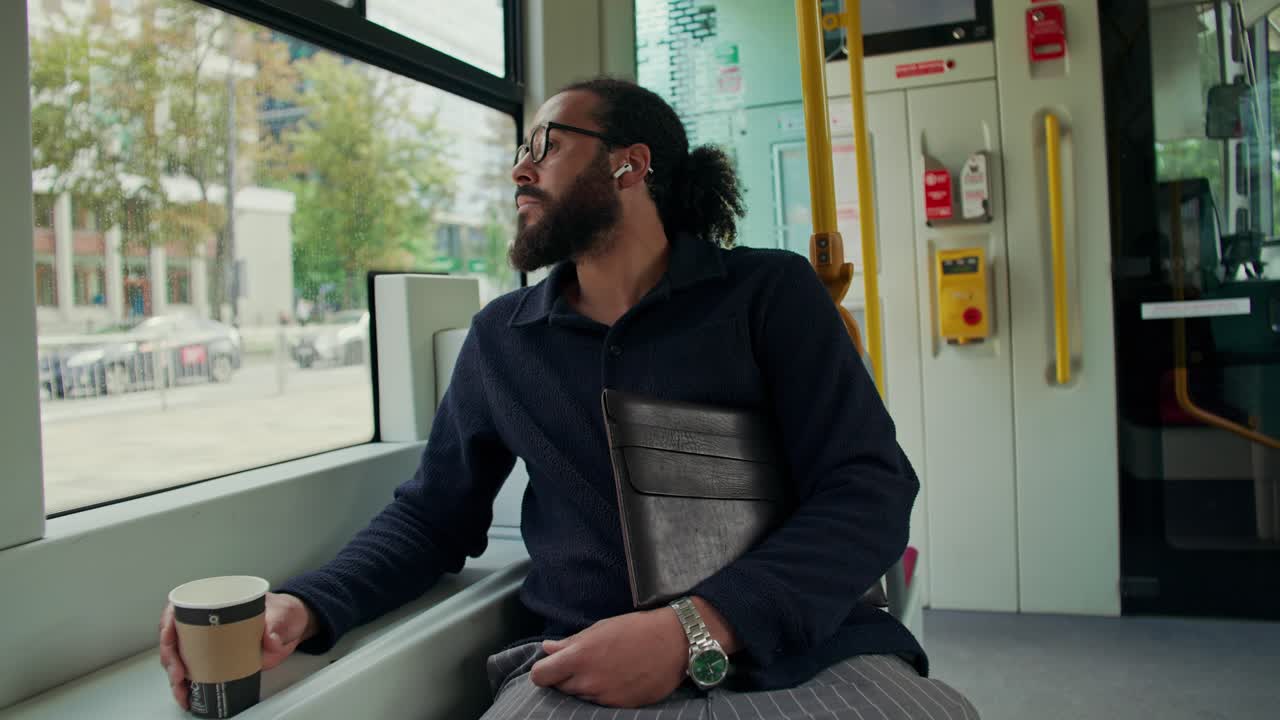 Man traveling on public transport with coffee and book