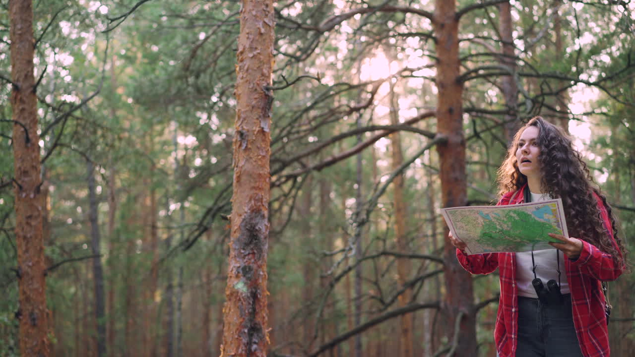 Woman Looking at Map in the Forest