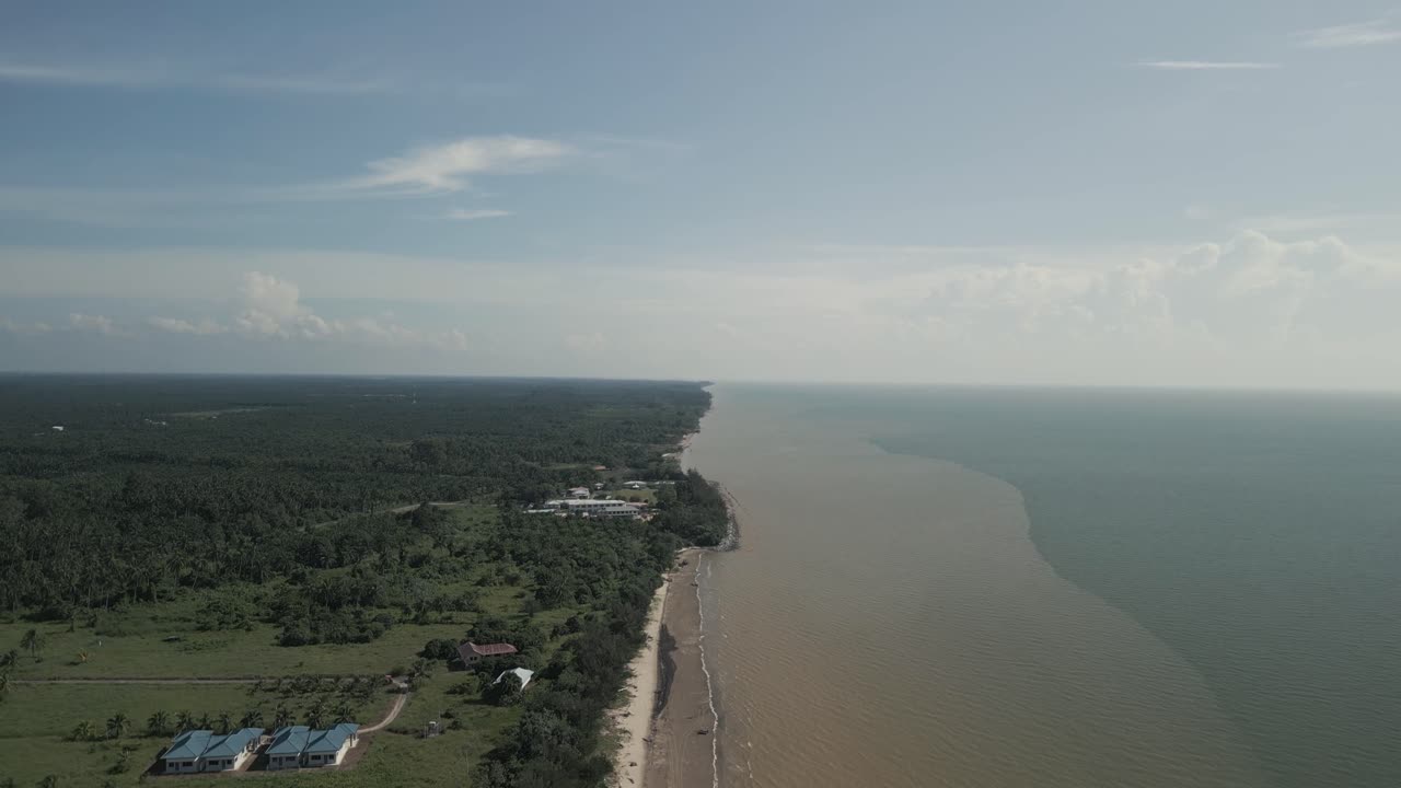 Ilmakuva dronella kesällä Alitin kalastajakylästä, Kabongista, avoimen sinisen meren, valkoisen hiekkarannan, vihreiden kookospalmujen ja joen äärellä, Sarawak, Borneo.