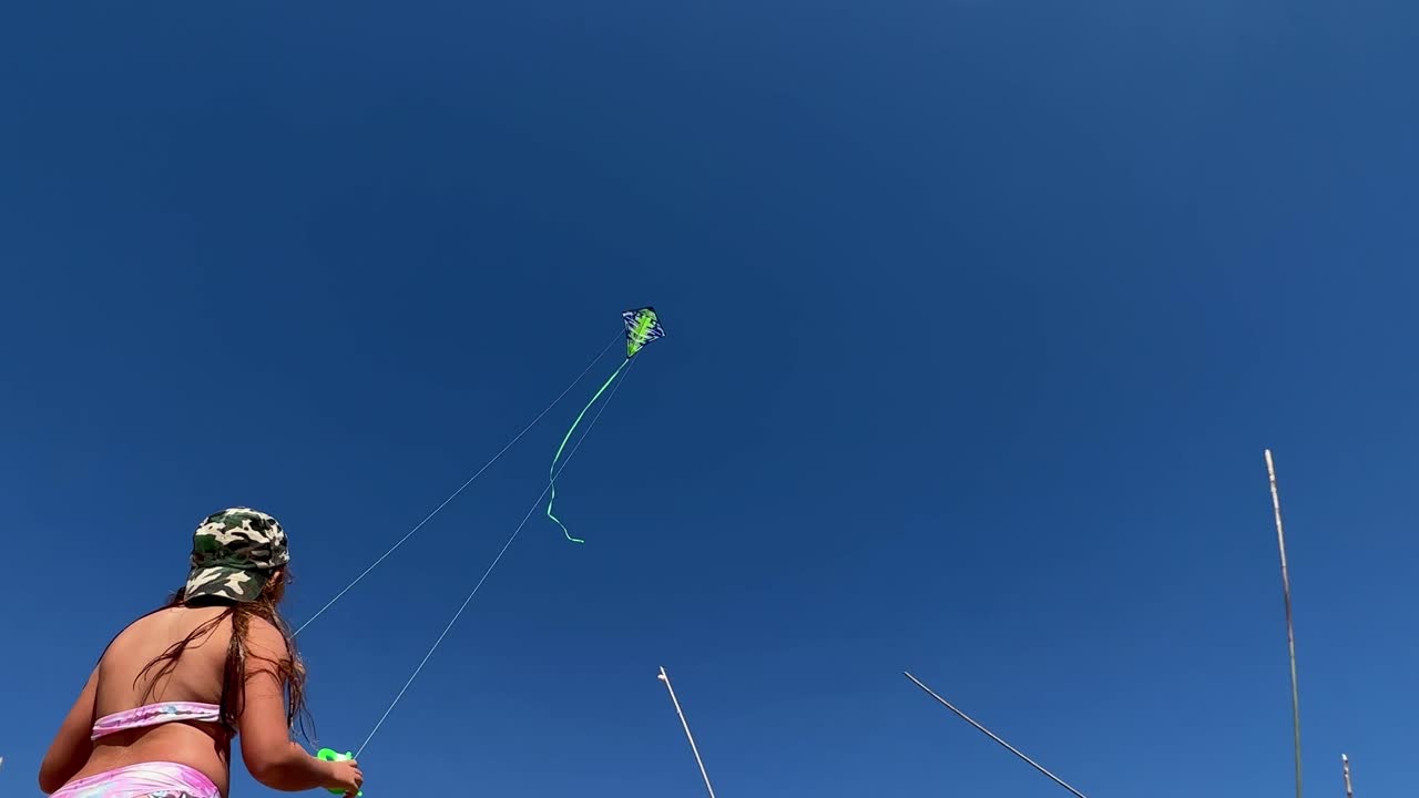 вид сзади под низким углом на стоящую маленькую рыжую девочку