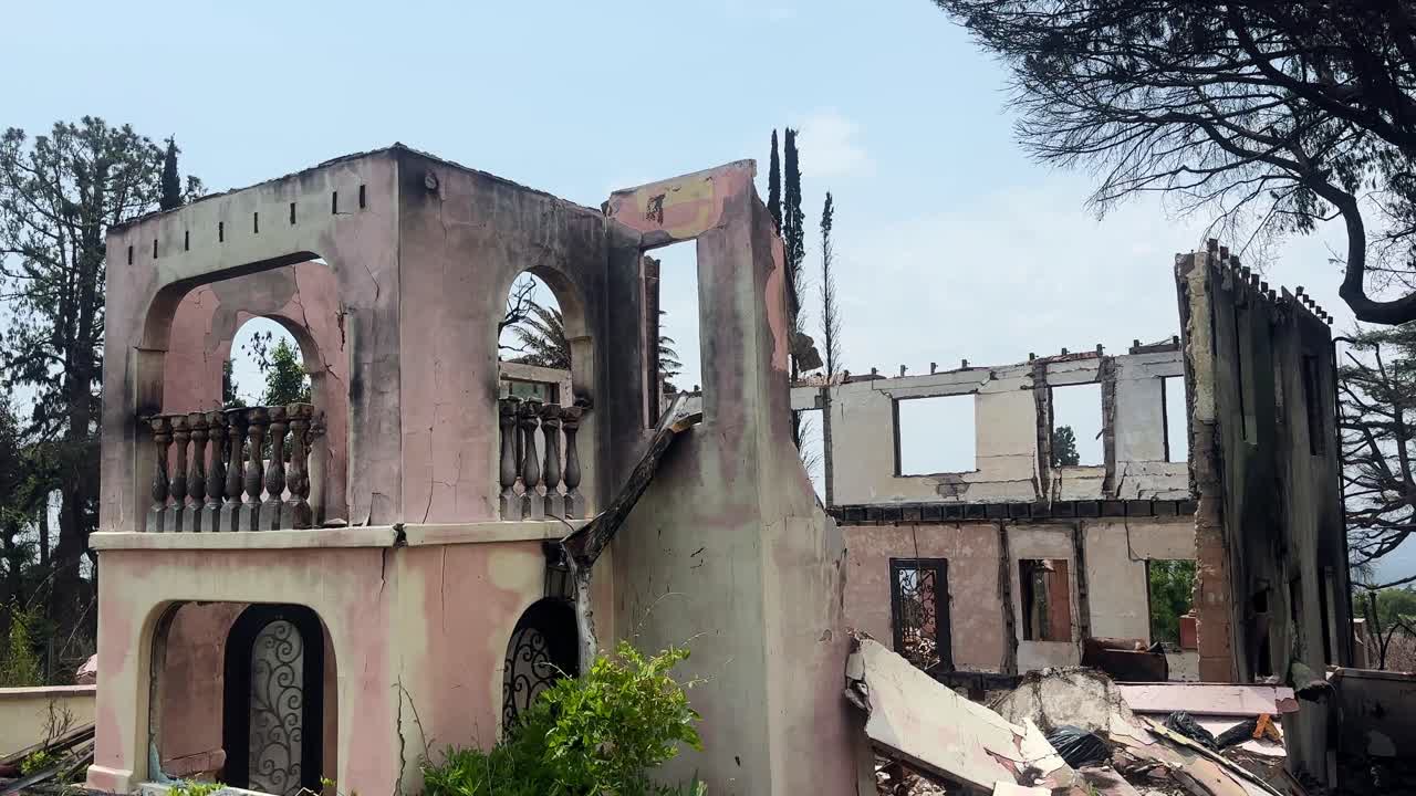Handheld booming down shot of a home burned by the Eaton wildfire in Altadena, California. 4K