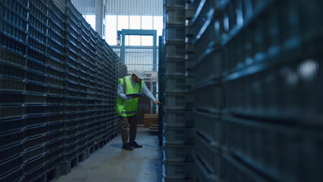 uniformed warehouse worker checking boxes shipment counting blue packages