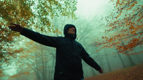 elderly man relaxes in an autumn mountain by walking to breathe with open arms