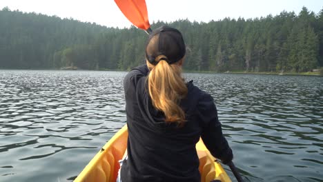 woman kayaking on a lake alone at sunset