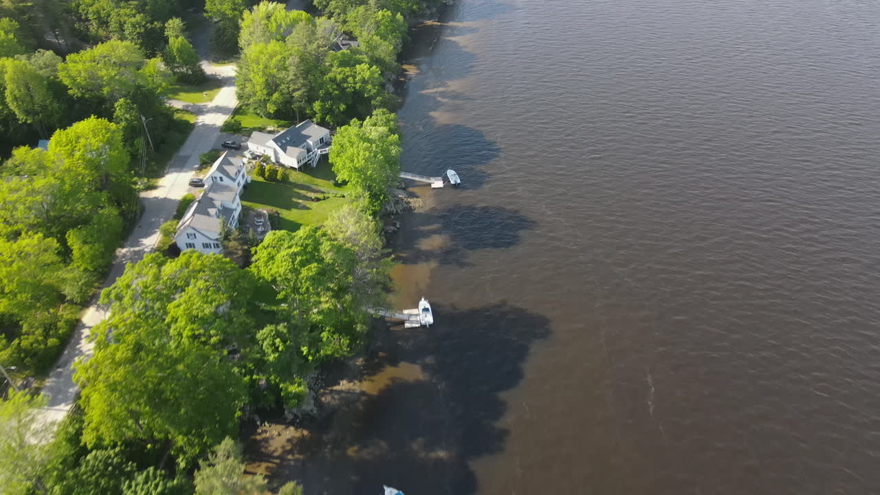 Aerial view of houses along a lake shoreline with boats and piers