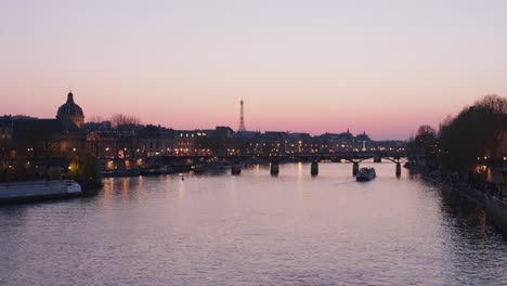 calm static wide shot of paris seine river during sunset with touristic boats