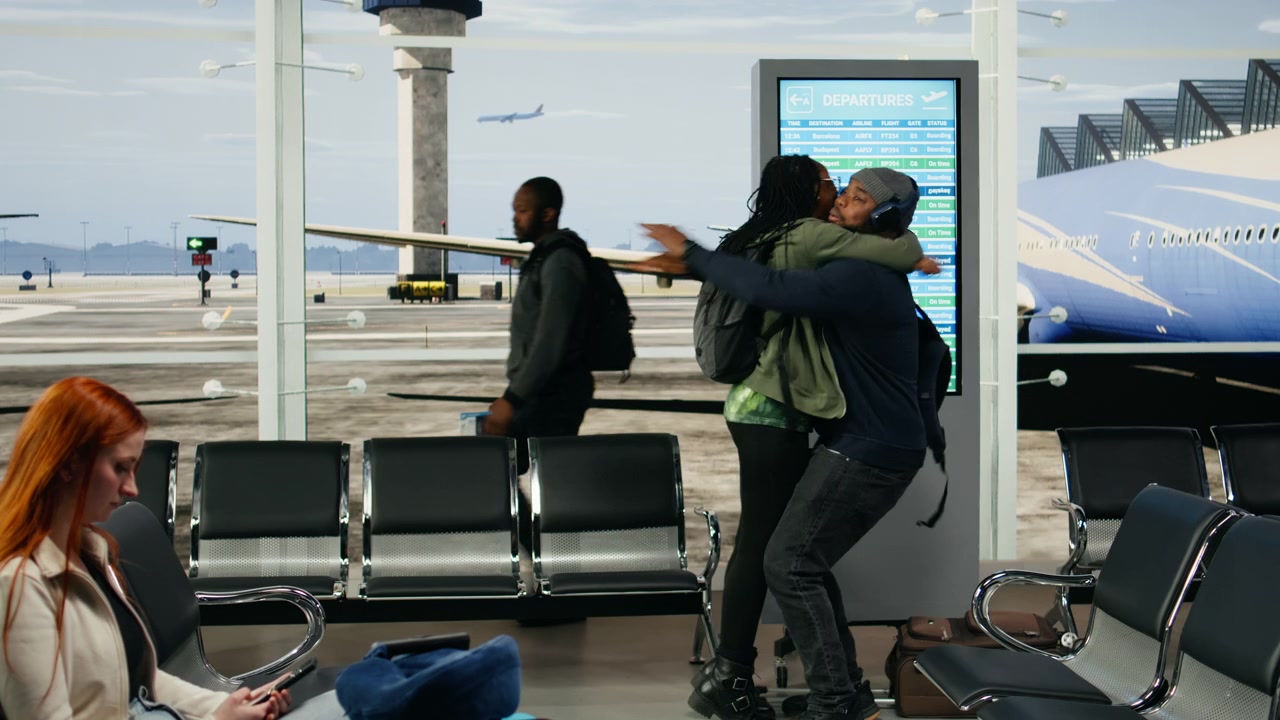 Emotional airport scene with black lovers hugging upon arrival