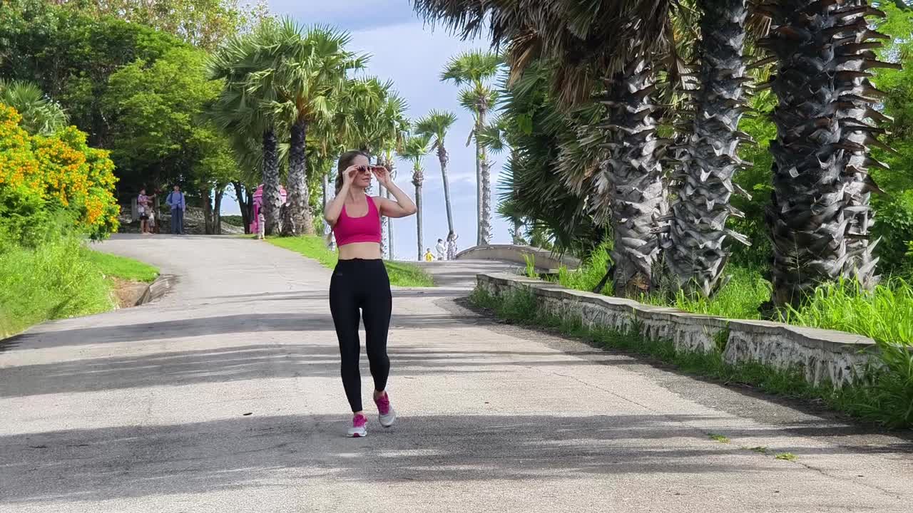 mujer caminando en un parque tropical