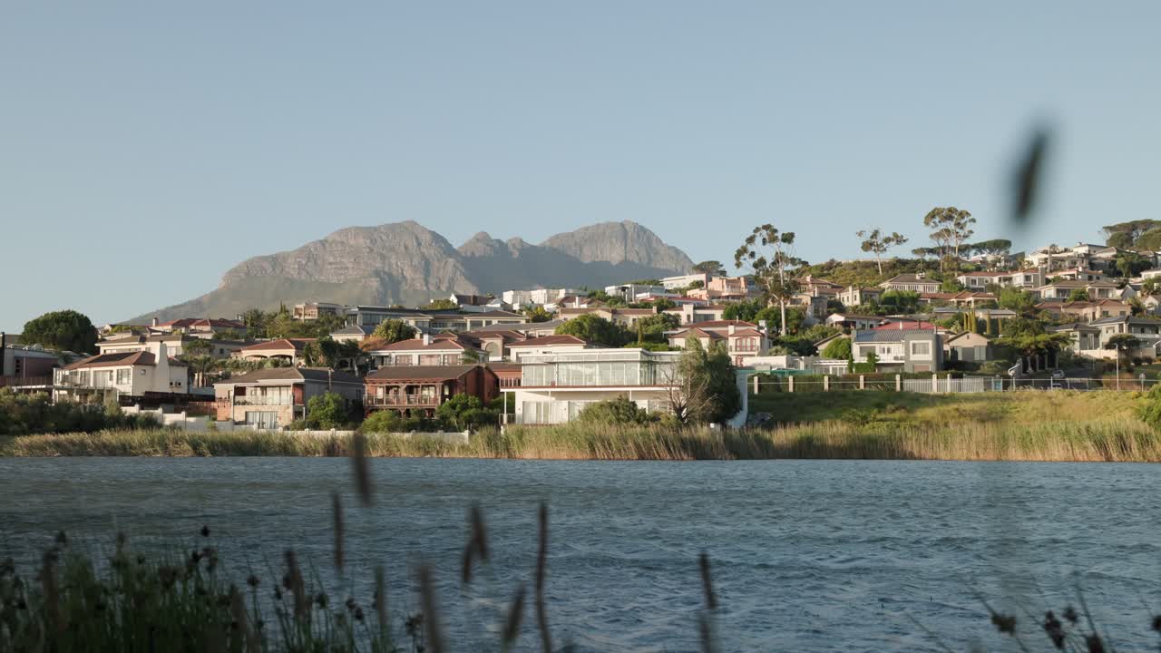 barrio de lujo en el suburbio de ciudad del cabo con montaña en el fondo. día de viento con vista al mar. hora de la puesta de sol en sudáfrica. área de vivienda de lujo.