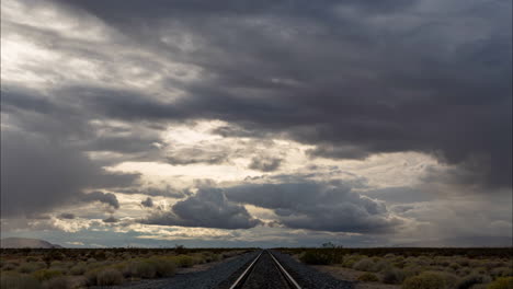 nubes pesadas a la deriva sobre vías de tren en el desierto, lapso de tiempo