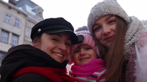 sisters tourists taking selfie, posing, making video conferencing on mobile phone with child girl